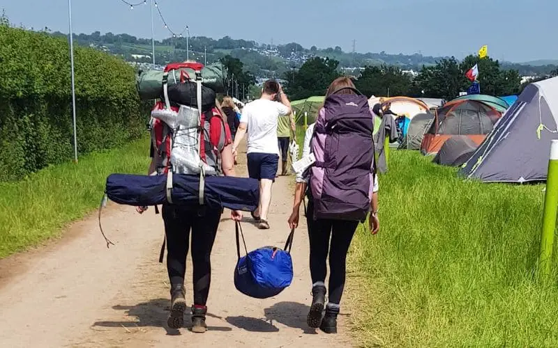 People carrying camping gear at Glastonbury